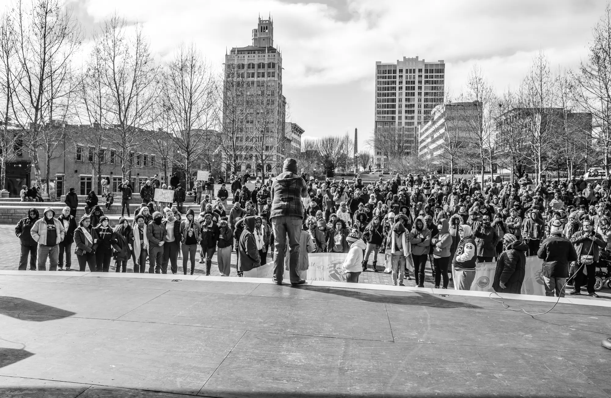 A black and white photo of a person at a podium addressing a crowd