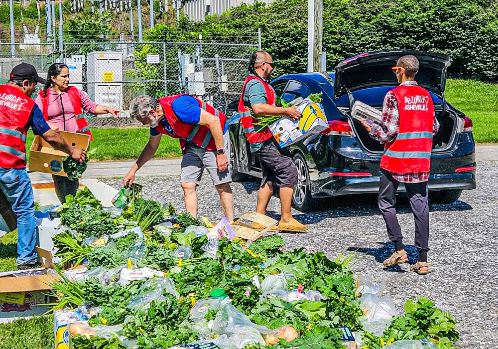 Volunteers loading up the back of a car with food boxes-1000x700