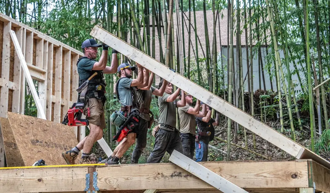 Village raising walls to a home